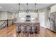 Bright kitchen featuring a large island with stool seating, modern light fixtures and stainless steel appliances at 11494 Colony Loop, Parker, CO 80138
