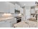 Modern kitchen featuring granite countertops, stainless steel appliances, white cabinets, and tile backsplash at 11494 Colony Loop, Parker, CO 80138