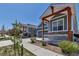 A street view of identical homes showcasing cozy porches, stone accents, and blue siding for neighborhood charm at 11494 Colony Loop, Parker, CO 80138
