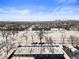 Broad aerial view displaying snow-covered landscape with Denver city skyline in the distance, blending nature and urban living at 3059 Curtis St, Denver, CO 80205