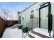 Backyard with a fence and stairs leading up to a door on the back of the house covered in winter snow at 3059 Curtis St, Denver, CO 80205