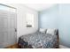 Cozy bedroom with a floral bedspread, neutral pillows, a light blue accent wall, and a window providing natural light at 3059 Curtis St, Denver, CO 80205
