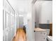 Bright entryway with white cabinets, closet, wooden floors and a glimpse into the bedroom featuring colorful floral bedding at 3059 Curtis St, Denver, CO 80205