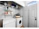 Functional laundry room with washer, dryer, shelving and convenient access to an exit door for practicality at 3059 Curtis St, Denver, CO 80205