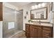 Bathroom featuring a glass shower, wood-look tile, and updated vanity with ample storage at 6132 Terry Ct, Arvada, CO 80403