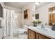 Bathroom featuring a shower/tub combo, oak vanity, and large mirror with ample lighting at 6132 Terry Ct, Arvada, CO 80403