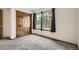 Bedroom featuring large windows, neutral carpeting, and a closet with natural wood doors at 6132 Terry Ct, Arvada, CO 80403