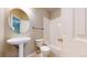 Well-lit bathroom featuring white fixtures, a combined tub and shower, and a pedestal sink at 9845 Keenan St, Highlands Ranch, CO 80130