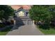 Charming two-story home featuring an attached three-car garage, attractive landscaping, and mature trees enhancing the property's appeal at 9845 Keenan St, Highlands Ranch, CO 80130