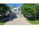 Charming two-story home featuring an attached three-car garage, attractive landscaping, and mature trees enhancing the property's appeal at 9845 Keenan St, Highlands Ranch, CO 80130
