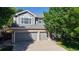 Two-story home with a three car garage and a large window at 9845 Keenan St, Highlands Ranch, CO 80130