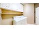 Functional laundry room equipped with washer, dryer, and ample overhead cabinet storage at 9845 Keenan St, Highlands Ranch, CO 80130