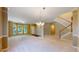 Spacious living room with staircase access, great light and plush carpeting at 9845 Keenan St, Highlands Ranch, CO 80130