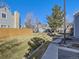 Exterior view of the property showing well-maintained landscaping, fencing, and residential buildings on a bright sunny day at 11612 E Cornell Cir, Aurora, CO 80014