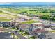 An aerial view showcases modern homes, retail spaces, green spaces, and a well-connected road network at 12953 Bridge View Ln, Parker, CO 80134