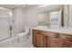 Bathroom showcasing a shower with glass doors, tile floors, a toilet, vanity with sink and wooden cabinetry at 12953 Bridge View Ln, Parker, CO 80134