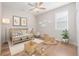 Bright Bedroom featuring a crib, ceiling fan, wood floors, neutral tones and playful decor creating a calming space at 12953 Bridge View Ln, Parker, CO 80134