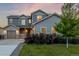 The exterior of a two-story home with a well-lit porch, landscaped yard, and a garage at 12953 Bridge View Ln, Parker, CO 80134