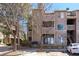 Multi-story condo building featuring stone accents, balconies, and mature trees on a sunny day at 7414 S Alkire St # 101, Littleton, CO 80127