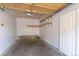 Unfinished garage with concrete floors, white walls, door, light fixture and shelving at 7414 S Alkire St # 101, Littleton, CO 80127
