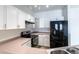 Bright kitchen featuring white cabinetry, stainless steel appliances, and modern lighting at 7414 S Alkire St # 101, Littleton, CO 80127