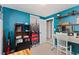 A bright bedroom with blue walls, a desk, and ample storage shelves at 902 Pacific Pl, Fort Lupton, CO 80621