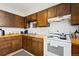Kitchen with dark wood cabinets, and white appliances at 902 Pacific Pl, Fort Lupton, CO 80621