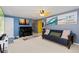 Inviting living room area with futon couch, piano, yellow door, and beach artwork at 902 Pacific Pl, Fort Lupton, CO 80621