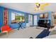Living room with blue walls, a piano, a surfboard, and large window at 902 Pacific Pl, Fort Lupton, CO 80621