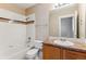Bathroom with a tub, toilet, vanity, and a mirror reflecting the doorway at 6000 W Floyd Ave # 116, Denver, CO 80227