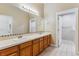 Bathroom featuring double sinks, a large mirror, and tile flooring for easy maintenance at 6000 W Floyd Ave # 116, Denver, CO 80227