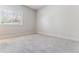 Empty bedroom with grey carpet and a window, flooded with natural light at 6000 W Floyd Ave # 116, Denver, CO 80227