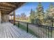 Spacious wood deck with black metal railings offers outdoor living with natural views at 6000 W Floyd Ave # 116, Denver, CO 80227