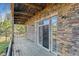 View of a covered deck with sliding doors and brick accents at 6000 W Floyd Ave # 116, Denver, CO 80227