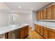 Bright kitchen showcasing light countertops, wood cabinets, and stainless steel dishwasher at 6000 W Floyd Ave # 116, Denver, CO 80227