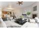 Open living room with a fireplace, neutral decor, and a view to the kitchen and dining area at 6000 W Floyd Ave # 116, Denver, CO 80227