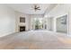 Light-filled living area with a fireplace, fan, balcony and access to another room at 6000 W Floyd Ave # 116, Denver, CO 80227
