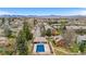 Aerial view featuring a community pool and well-manicured green spaces, with mountain views in the distance at 3656 S Depew St # 102, Denver, CO 80235