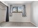A carpeted bedroom with a closet and a window with curtains, providing soft, natural light at 3656 S Depew St # 102, Denver, CO 80235