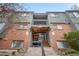 A charming exterior entrance with wooden stairs and a balcony above a unit's front door at 3656 S Depew St # 102, Denver, CO 80235