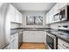 A well-lit kitchen features modern appliances, a sink beneath a window, and stylish countertops at 3656 S Depew St # 102, Denver, CO 80235
