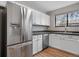This kitchen features stainless steel appliances, modern cabinets, a stylish backsplash, and wood flooring at 3656 S Depew St # 102, Denver, CO 80235