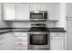 This kitchen features stainless steel appliances, modern cabinets, and a stylish backsplash at 3656 S Depew St # 102, Denver, CO 80235