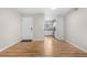Open-concept living room with wood floors, a bright white front door, and easy access to the kitchen at 3656 S Depew St # 102, Denver, CO 80235