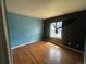 Bedroom with hardwood floors, dual-tone blue-black paint, and natural light at 1021 Downing Way, Denver, CO 80229