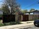 Back yard perimeter fence and driveway featuring mature trees and garage with alley access at 1021 Downing Way, Denver, CO 80229