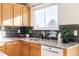 Kitchen with dark-colored tile backsplash and wood cabinets at 5604 S Yakima Way, Aurora, CO 80015