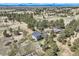 Aerial view showcases acreage with two homes and a detached garage amongst lush trees at 12454 Antelope Trl, Parker, CO 80138