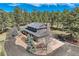 An aerial view of a grand home with mature pine trees and an asphalt driveway at 12454 Antelope Trl, Parker, CO 80138