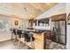 Stylish bar area with wood accents, modern appliances, counter seating, and a flat-screen TV for entertaining guests at 12454 Antelope Trl, Parker, CO 80138